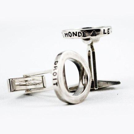 two silver cufflinks engraved with the phrase “Tout le monde a le droit”