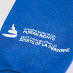 Blue sweater sleeve with a white Canadian Museum for Human Rights logo, and the words “Canadian Museum for Human Rights” in English and French near the cuff.