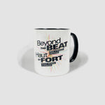White mug with a black interior and handle. The “Beyond the Beat” logo is printed in English and French on it.