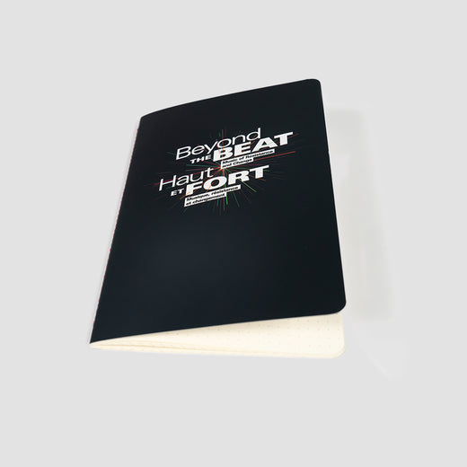 Notebook with a black cover featuring the “Beyond the Beat” logo in English and French.