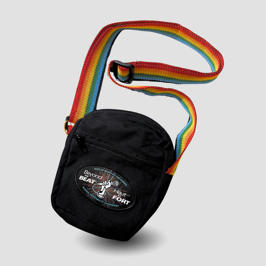 Black crossbody bag featuring the “Beyond the Beat” logo in English and French, with an adjustable colourful soft webbing strap.