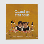 Book cover with the title “Quand on était seuls” Featuring two young people laying in leaves wearing uniforms.