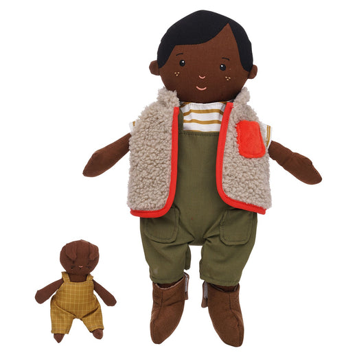 A dark-skinned cloth doll with short black hair with a brown cat next to it. They are both wearing coveralls and Ellis is also wearing a striped shirt, a red and beige vest and brown boots.