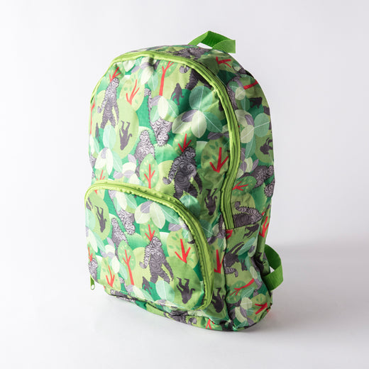 green and brown backpack featuring a patterned print of sasquatch in the forest