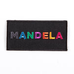 black patch featuring the text “MANDELA” in multi-coloured and multi-patterned capital letters