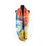 a scarf that features an illustration of a circle, radiant lines and abstract shapes with vibrant colours