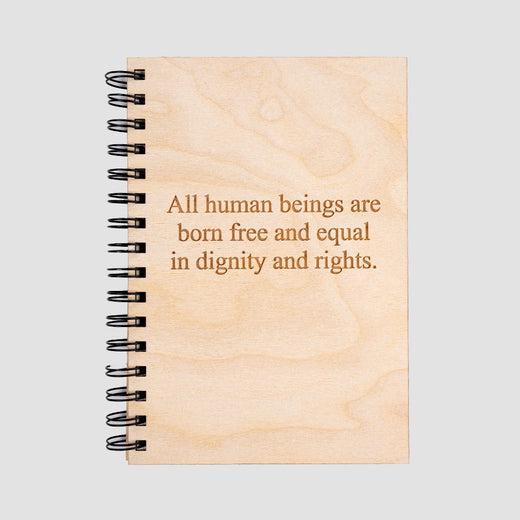 Wooden cover of journal with the quote “All human beings are born free and equal in dignity and rights.”