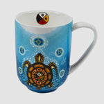The mug’s design features a turtle with a medicine wheel on its back. The turtle is surrounded by small white bubbles and seven larger circles.