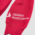 Red sweater sleeve with a white Canadian Museum for Human Rights logo, and the words “Canadian Museum for Human Rights” in English and French near the cuff.