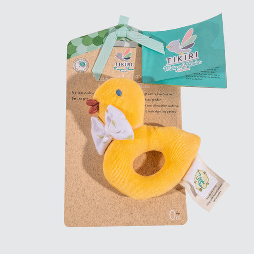 Vibrant yellow fabric toy in an oval shape, attached to its packaging. One extremity is in the shape of a duck’s head with a white bow tie.
