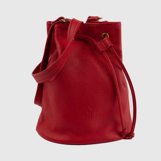 Red leather bucket bag with drawstrings and shoulder strap.